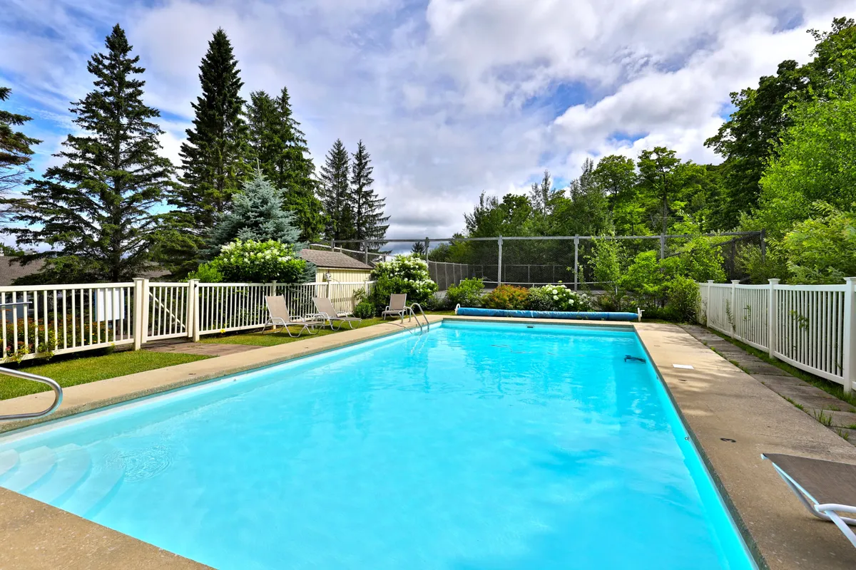 A tranquil swimming pool set amid greenery, with spacious lounge chairs arranged poolside. The peaceful environment invites relaxation and outdoor enjoyment.